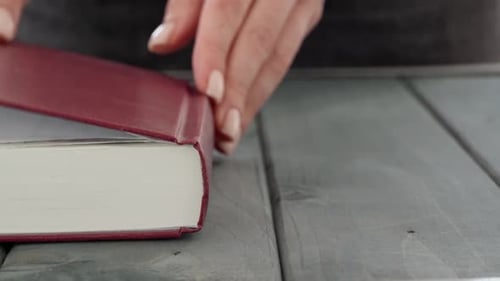 Close Up of Female Hands Turning Pages of a Book