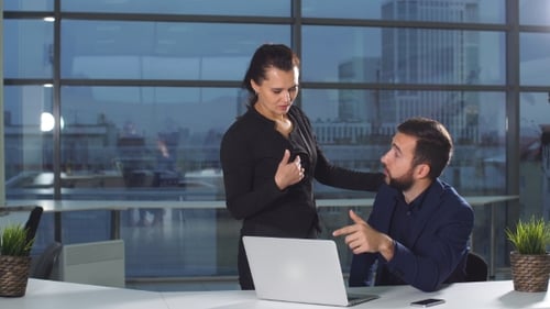Young Business Couple Talking and Using Tablet in Office