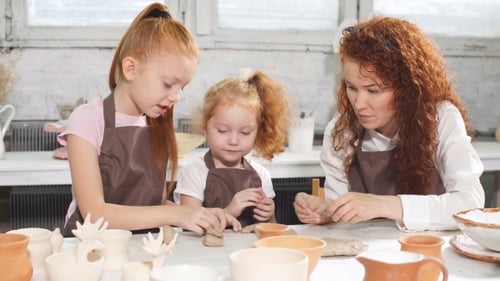 Kid and Teacher Are in Workshop. Kid's Hands Are Sculpting a Figurine.