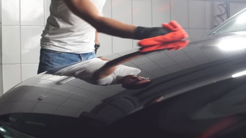 Man Worker Polishing Car on a Car Wash.