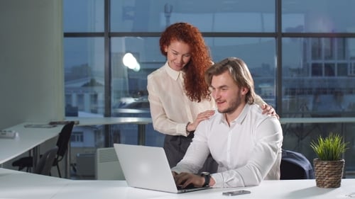 Colleagues Collaborating on Laptop in Modern Office