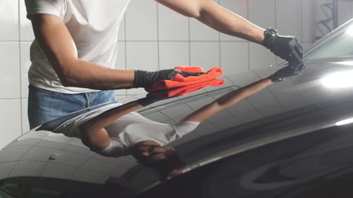 Man Worker Polishing Car on a Car Wash.