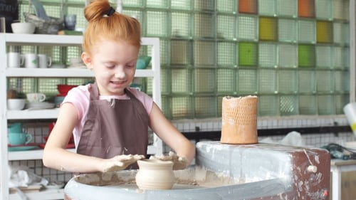 Cheerful Girl Making Pottery on a Wheel