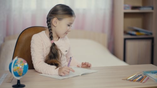 Girl Doing Homework at Desk in Bright Room
