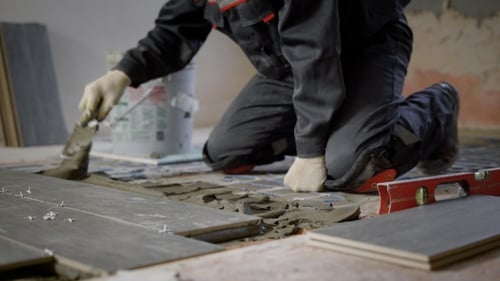 Anonymous Constructor Working on Site and Applying Cement on Floor