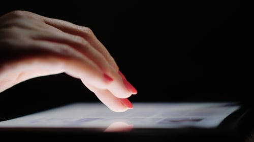 Internet Browsing on the Tablet. Female Fingers Scroll Text Screen