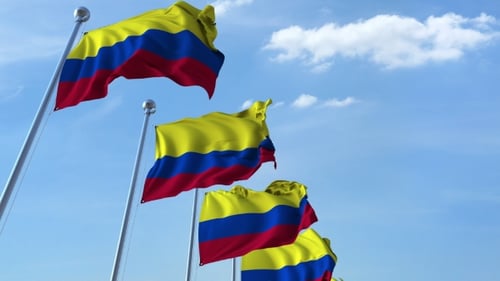 Multiple Waving Flags of Colombia Against the Blue Sky