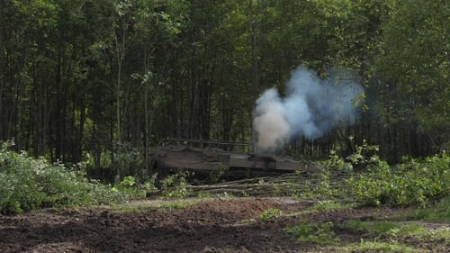 Tanque del ejército destruye bosque verde para construir un camino en el bosque en el campo de tiro