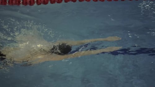 Woman Swimmer in Goggles Floating Breaststroke in Water Swimming Pool