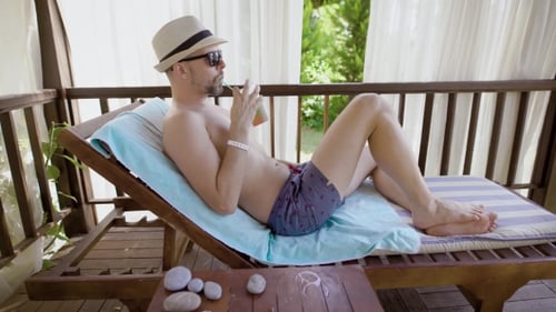 Man Relaxes on Lounge Chair, Tropical Holiday