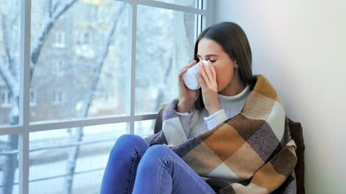 Pensive Beautiful Woman Sitting on Window Enjoying Looking at Winter Scene
