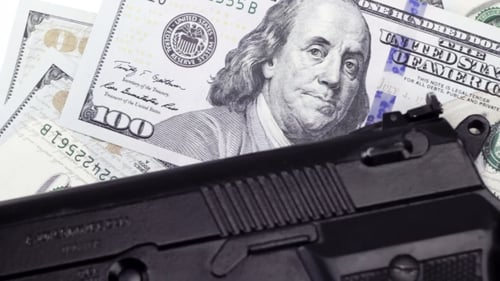 Billetes de cien dólares en efectivo bajo el arma, fondo giratorio
