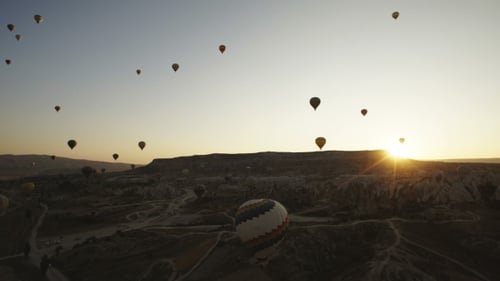 Colorful Hot Air Balloons Flying Over Red Valley at Cappadocia on Sunset