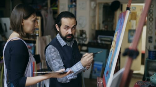 Un artiste habile apprend à une jeune fille à dessiner des peintures et explique les bases de la lumière dans l'art