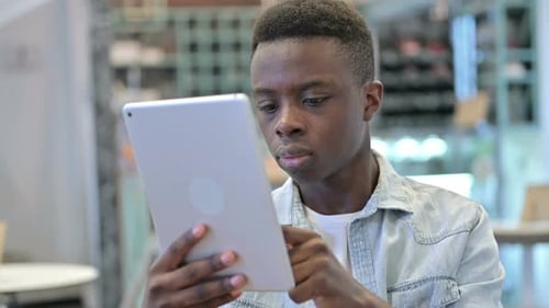 Young adult uses digital tablet device at home