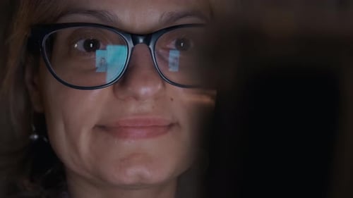 Girl's Eyes in Glasses, Girl Watch and Read Something From Screen Smartphone at Night Time. Close Up