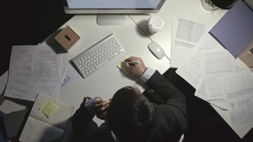 Man Taking Notes While Talking on Phone