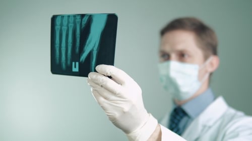 the Doctor Is Engaged in His Work in the Hospital Examines an X-ray of the Hand an Ambulance To