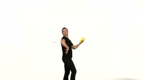 Man Juggling White Club and Yellow Container