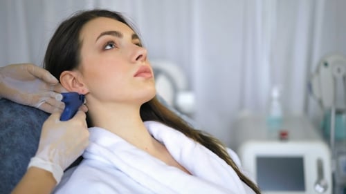 Beautician Doing Ear Piercing Procedure in Beauty Salon