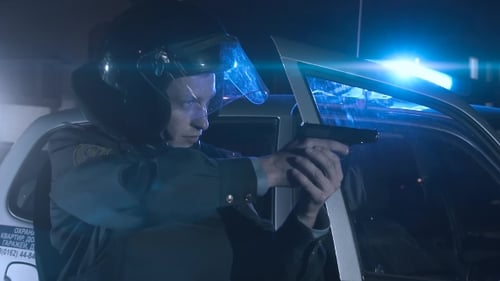 Officer Holding Gun Next to Police Car at Night