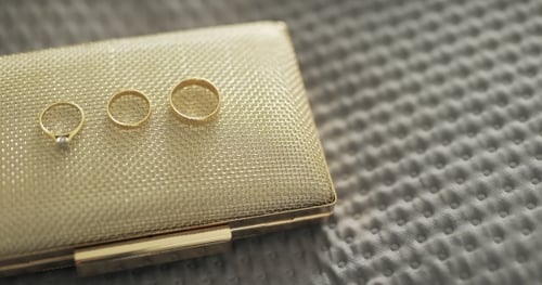 Elegant Wedding Rings on a Gold Clutch