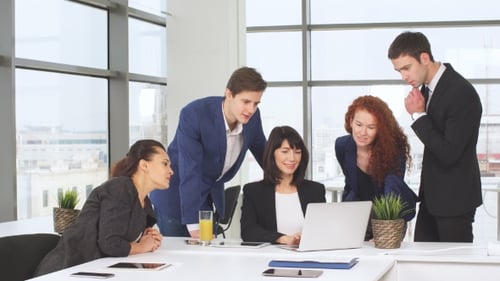 Team Collaboration Around Laptop in Modern Office