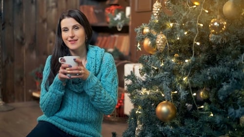 Woman Relaxing with Coffee by Christmas Tree