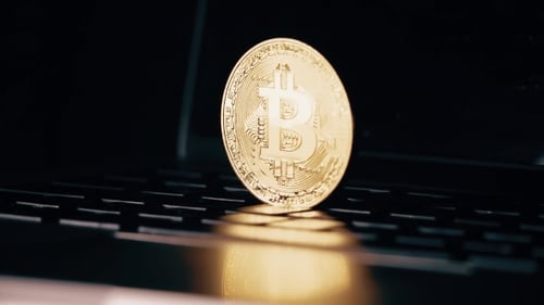 Golden Bitcoin Coin Falling on Computer Keyboard