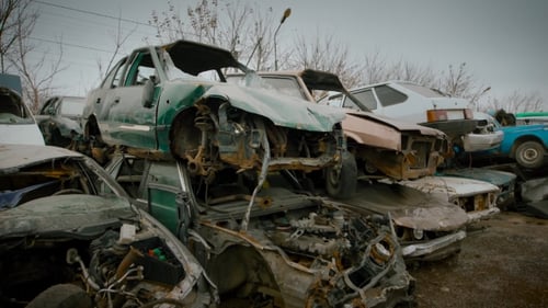 Kaputte Autos, die auf der Mülldeponie von Fahrzeugen stehen, verrostete und kaputte Autos warten