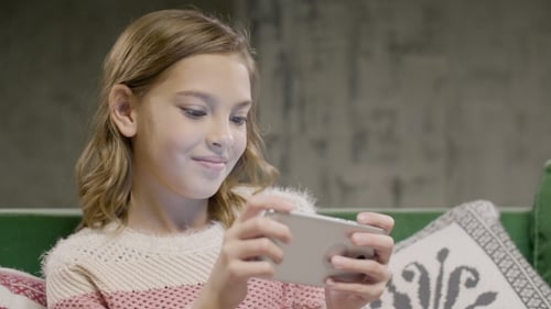 Girl Playing on Cell Phone at Home