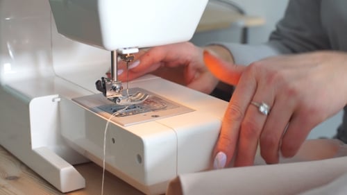 Woman Uses Sewing Machine to Sew Fabric