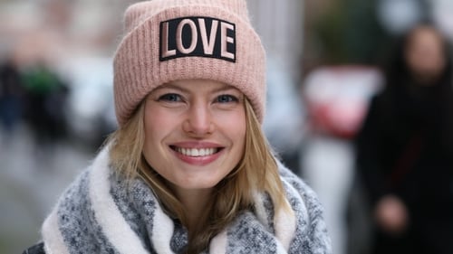 Smiling Woman in Pink Hat on City Street
