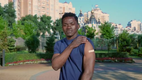 Man with Vaccine Bandage in Urban Park
