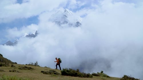 Man with Backpack Climb the Mountain Slope in the Himalayas