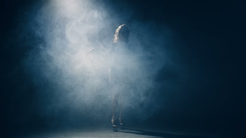 Junge Frau mit langen Haaren in High Heels tanzt