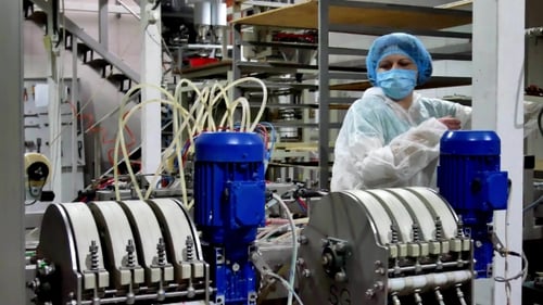 Employee Controls Filling Machine for Spilling Any Liquids
