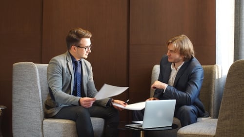 Two Men Discuss Business in Modern Office