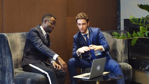Businessmen Discussing Details on Laptop in Modern Office