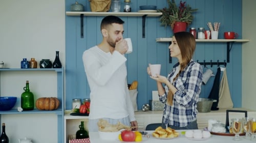 Young Couple Talking in a Sunny Kitchen