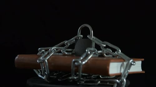 Book Locked with Chain on Black Background