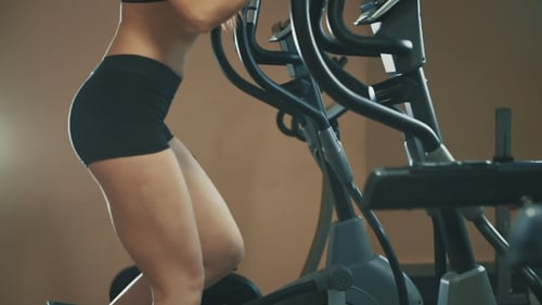 Sporty Girl Doing Exercises on Special Ellipsoid Simulator in Gym
