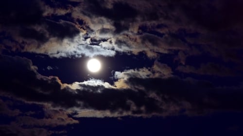 Moody Clouds Passing the Bright Full Moon at Night