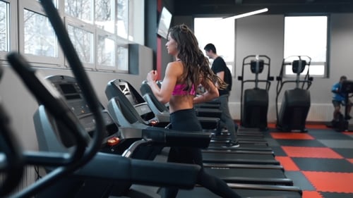 Active Woman Exercising on Treadmill in Gym