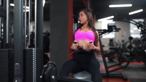 Beautiful Woman at the Sports Club Does Different Kind of Exercises on the Simulators for Being in