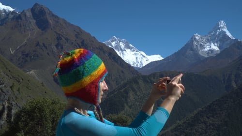 Woman Taking Pictures With Mountain Range Background
