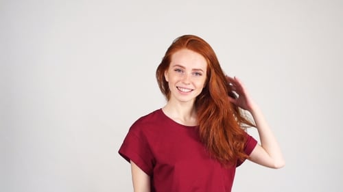 Pretty Cheerful Redhead Girl Laughs on the Camera on White Background