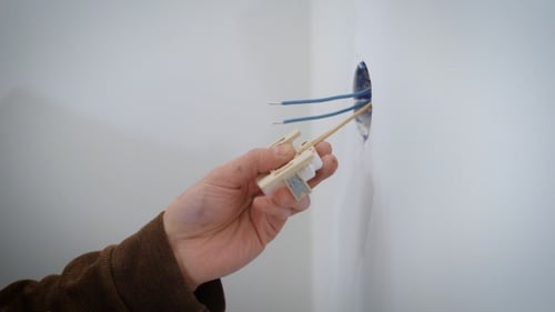 Wireman Is Connecting Wires To a Mechanism of Electric Outlet During Repair Indoors