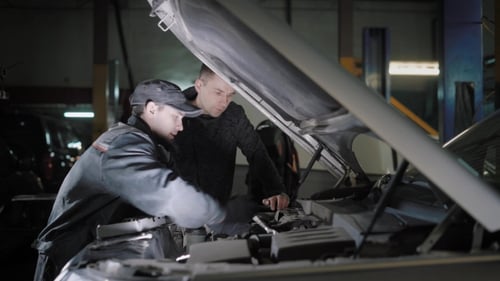 Mechanics Working on Car Engine at Night