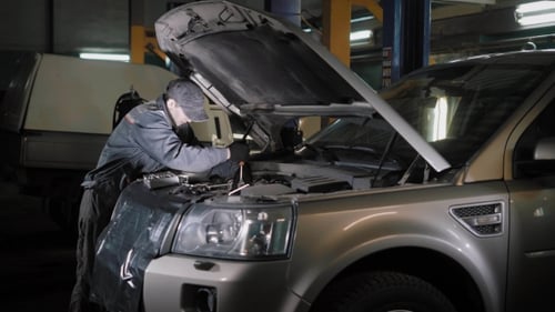 Auto Mechanic Repairing Silver SUV Car Engine